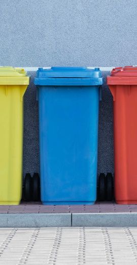 image de poubelles de couleur jaune bleu rouge vert dans la rue